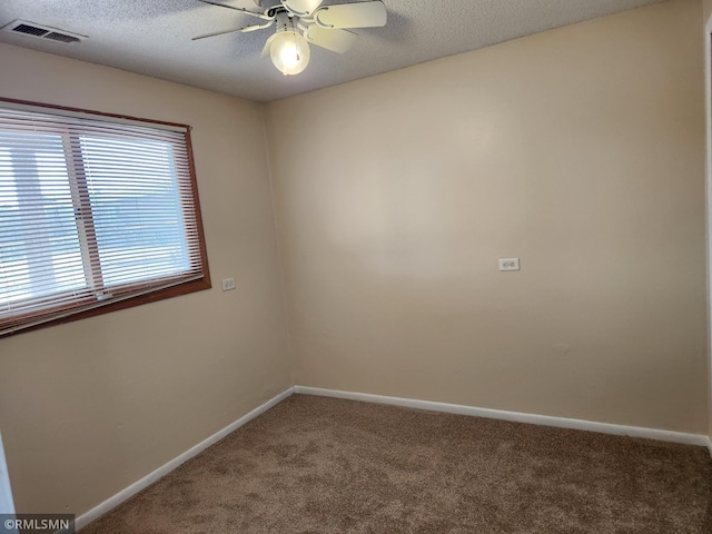 unfurnished room with visible vents, a textured ceiling, baseboards, and carpet floors