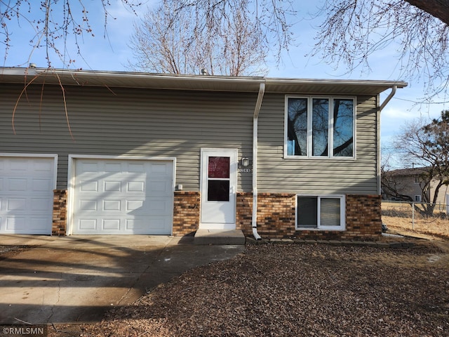 view of front of house featuring a garage, brick siding, and driveway