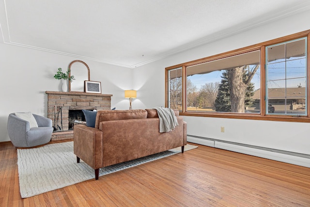 living area with a baseboard heating unit, light wood-style flooring, a fireplace, and ornamental molding