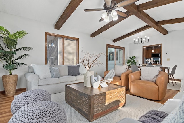 living area featuring ceiling fan with notable chandelier, light wood-style flooring, vaulted ceiling with beams, and baseboards