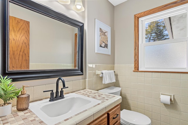 half bath featuring a wainscoted wall, toilet, tile walls, and vanity