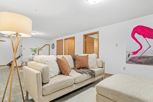 living room featuring baseboards and a textured ceiling