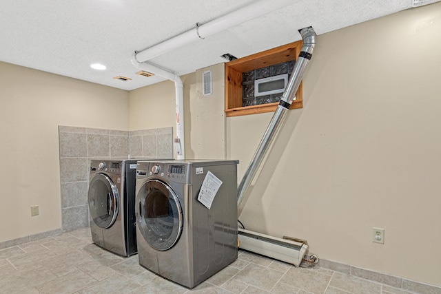 laundry area featuring washing machine and clothes dryer, laundry area, visible vents, and a baseboard radiator