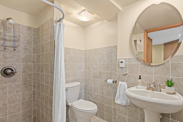 full bathroom featuring a sink, tile walls, toilet, and tiled shower