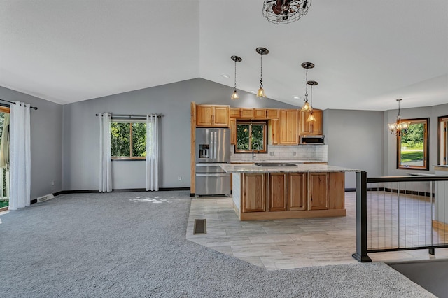 kitchen featuring light colored carpet, backsplash, a center island, stainless steel appliances, and a sink