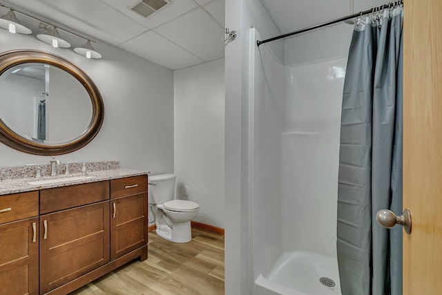 full bath with a stall shower, visible vents, toilet, wood finished floors, and vanity