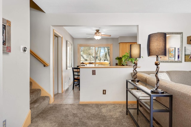 interior space featuring visible vents, baseboards, light colored carpet, ceiling fan, and light tile patterned flooring