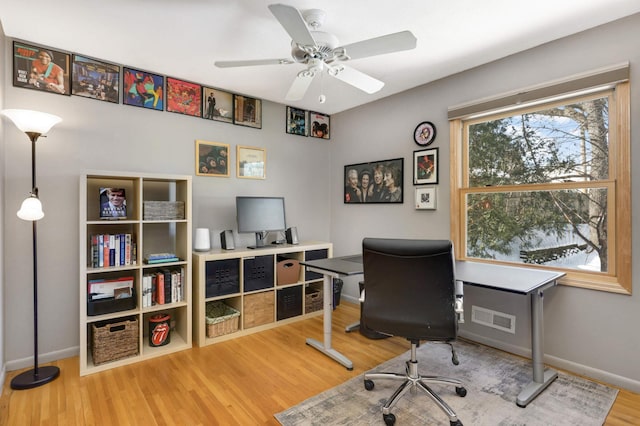 office featuring a ceiling fan, wood finished floors, visible vents, and baseboards