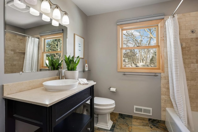 full bath featuring baseboards, visible vents, toilet, shower / bath combination with curtain, and stone tile flooring