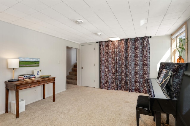 living area featuring stairway and carpet