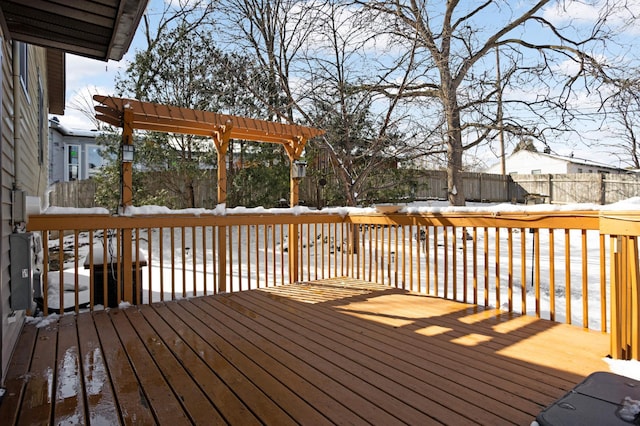 snow covered deck featuring fence and a pergola