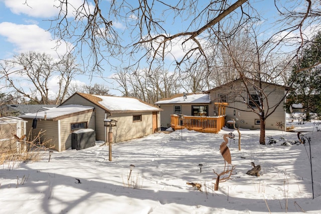 snow covered house with a wooden deck