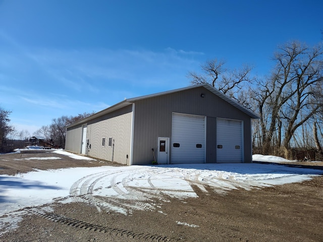 snow covered garage with a garage