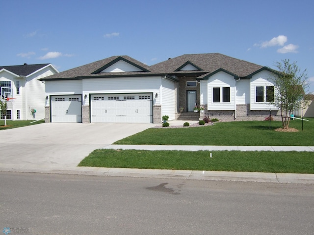 view of front of property with a front lawn, an attached garage, driveway, and a shingled roof