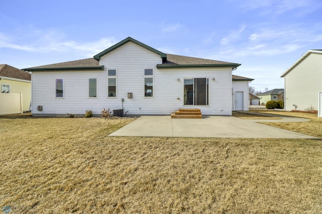 rear view of house with entry steps, central air condition unit, a patio area, and a lawn