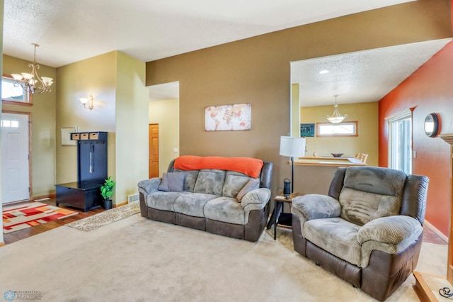 living room featuring baseboards, visible vents, carpet floors, and an inviting chandelier