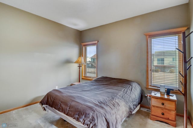 carpeted bedroom with visible vents and baseboards