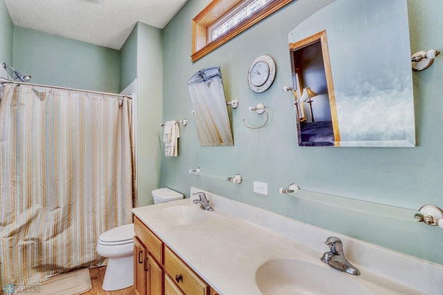 full bath with curtained shower, double vanity, toilet, and a sink