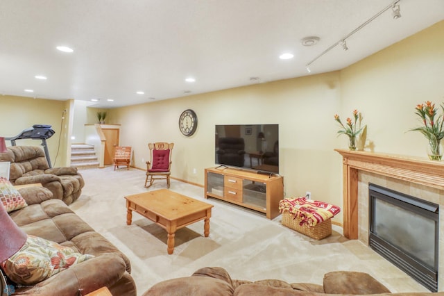 carpeted living area featuring stairway, baseboards, recessed lighting, a fireplace, and track lighting