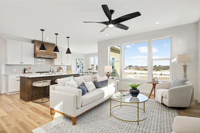 living area with recessed lighting, baseboards, light wood-style floors, and ceiling fan