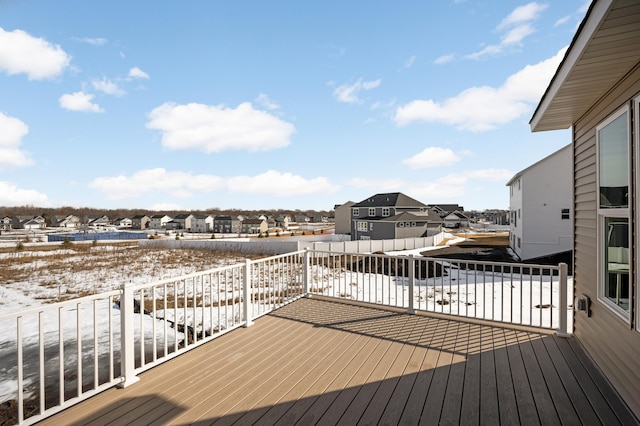 snow covered deck with a residential view