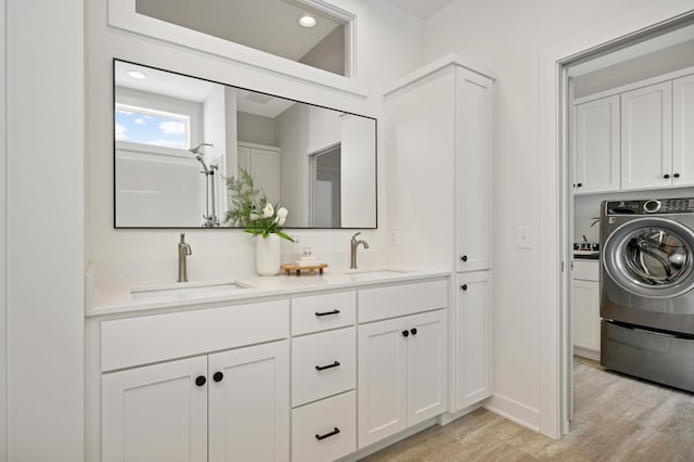 full bathroom featuring double vanity, wood finished floors, washer / clothes dryer, and a sink