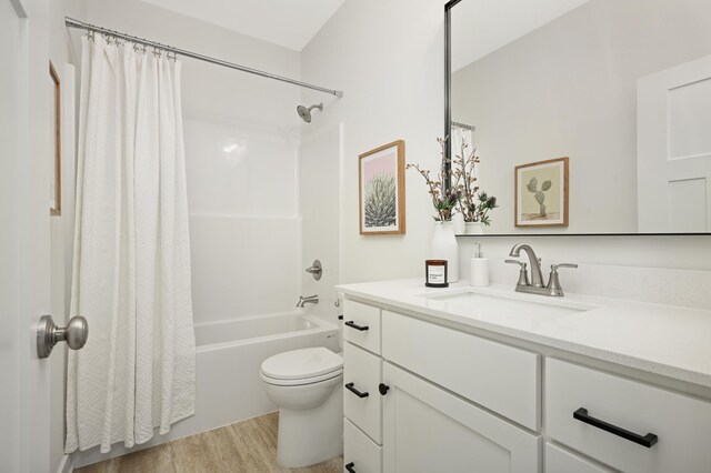 bathroom featuring shower / tub combo with curtain, toilet, wood finished floors, and vanity