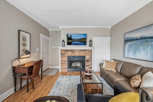 living area with light wood-type flooring, baseboards, a fireplace, and crown molding