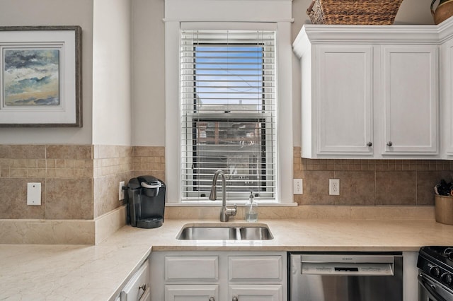 kitchen with white cabinetry, a sink, light countertops, dishwasher, and backsplash