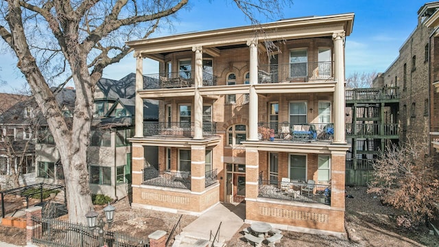 view of front facade featuring a balcony and brick siding