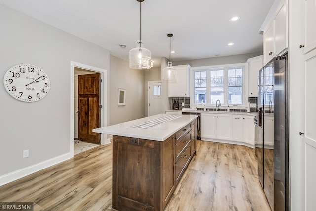 kitchen with light wood-style flooring, refrigerator with ice dispenser, and white cabinets