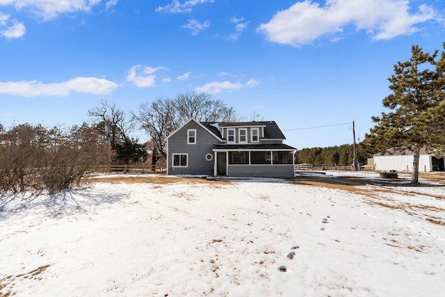 view of front of property with a sunroom and fence