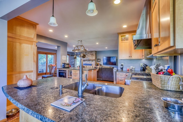 kitchen with recessed lighting, a peninsula, a sink, hanging light fixtures, and island exhaust hood