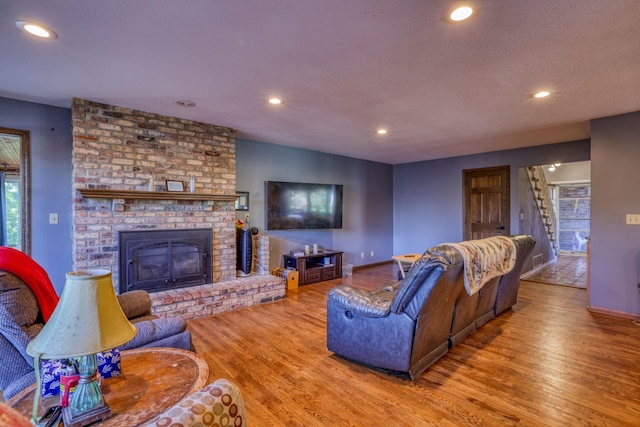 living area with stairs, a fireplace, wood finished floors, and recessed lighting