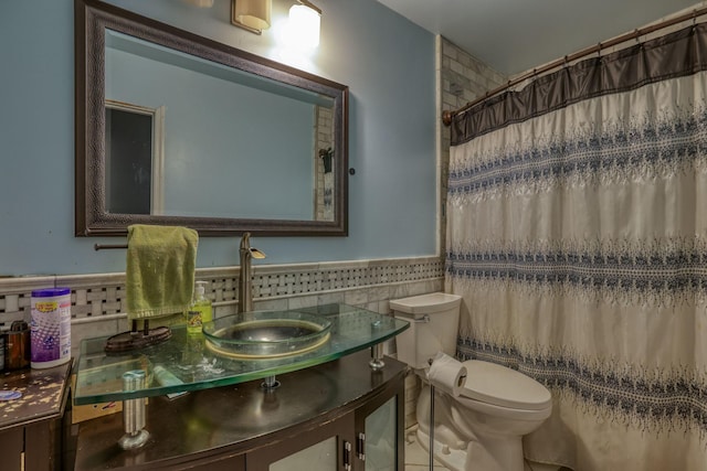 full bath with tile walls, toilet, wainscoting, vanity, and a shower with curtain