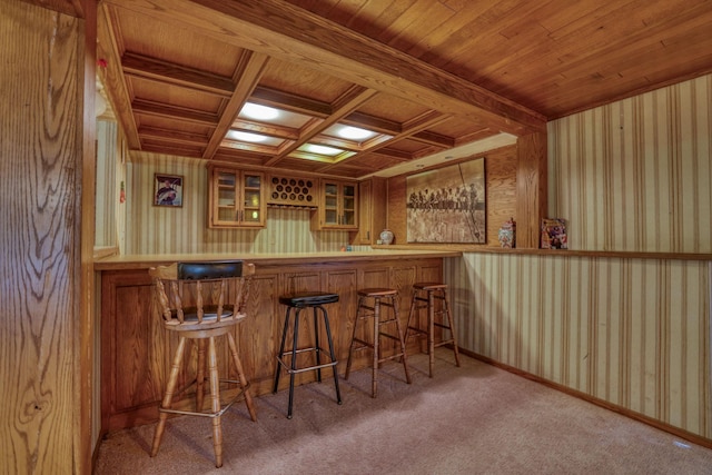 bar featuring wallpapered walls, coffered ceiling, indoor bar, wooden ceiling, and carpet floors