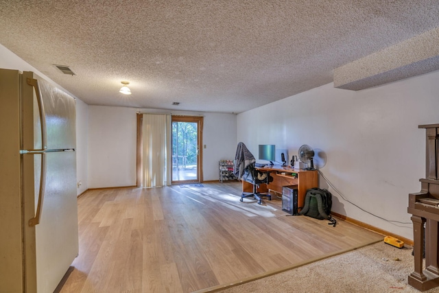 office space with baseboards, a textured ceiling, visible vents, and wood finished floors