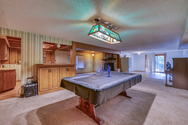 playroom featuring light carpet, wallpapered walls, pool table, a textured ceiling, and a fireplace