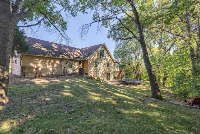 view of front of home featuring stairs, a deck, central AC, and a front yard