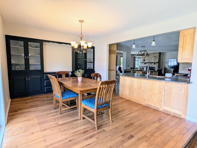 71 Deer Hills Ct, North Oaks, MN 55127 - dining space featuring light wood-style floors, a chandelier, and a fireplace