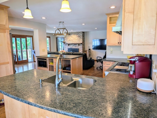 71 Deer Hills Ct, North Oaks, MN 55127 - kitchen featuring a fireplace, light brown cabinetry, a sink, wall chimney exhaust hood, and recessed lighting