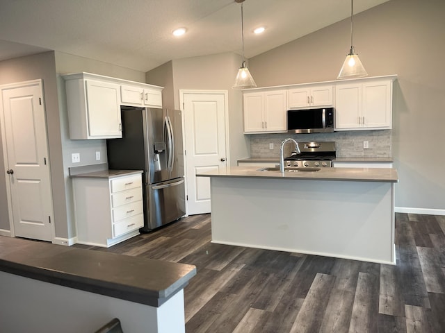 kitchen with stainless steel appliances, a sink, white cabinets, vaulted ceiling, and dark wood-style floors