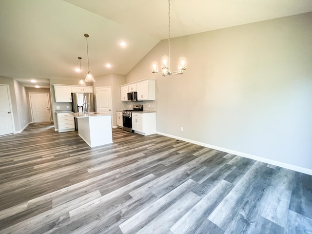 kitchen with open floor plan, stainless steel appliances, wood finished floors, and white cabinetry