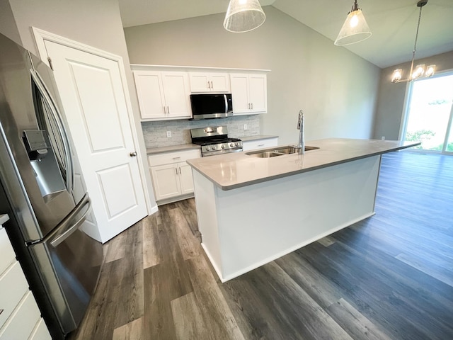 kitchen with stainless steel appliances, dark wood-type flooring, a sink, tasteful backsplash, and decorative light fixtures