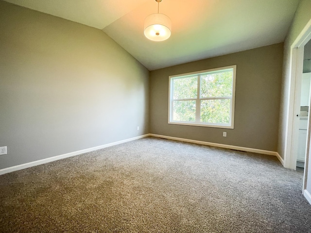 spare room featuring lofted ceiling, baseboards, and carpet flooring