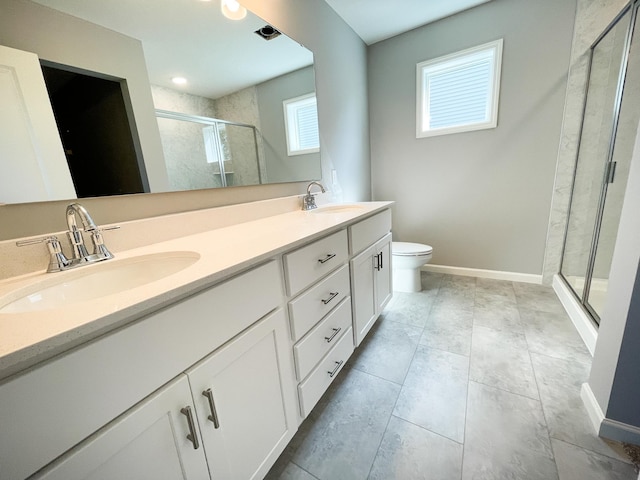 bathroom featuring double vanity, a stall shower, baseboards, and a sink