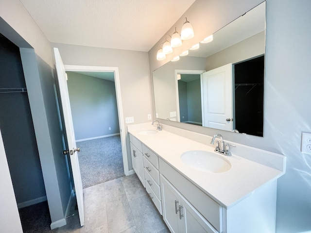 bathroom featuring a sink, baseboards, and double vanity