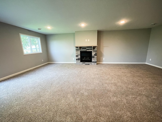 unfurnished living room with a fireplace, baseboards, carpet flooring, and recessed lighting