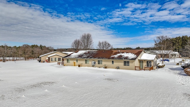 view of snow covered back of property