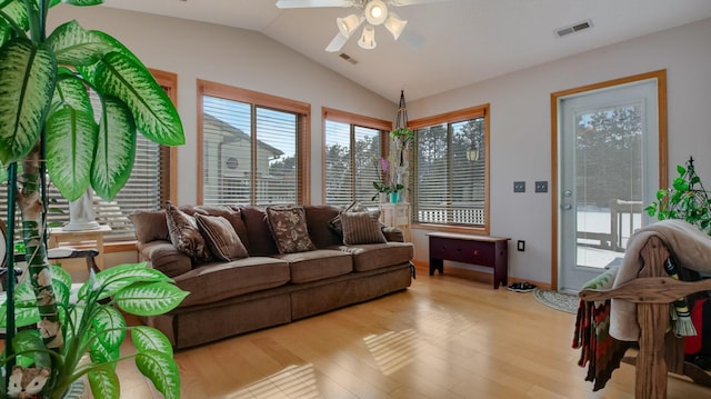 living room featuring vaulted ceiling, ceiling fan, light wood finished floors, and visible vents